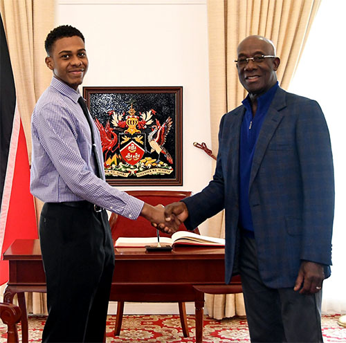 Prime Minister of Trinidad and Tobago Dr. Keith Rowley with essay winner Diego Barnett of Queen's College High School, Guyana (8-24-2023)
